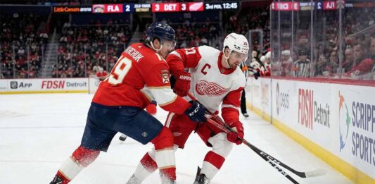 Florida Panthers' Matthew Tkachuk and Detroit Red Wings' Dylan Larkin battling for puck possession in a game available to watch on TV and stream live.