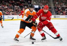 Philadelphia Flyers’ Travis Konecny battles for the puck against Detroit Red Wings captain Dylan Larkin during their March 28, 2026 matchup at Little Caesars Arena.