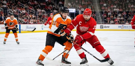 What Channel is the Flyers vs. Red Wings Game On? | March 28, 2026 Philadelphia Flyers’ Travis Konecny battles for the puck against Detroit Red Wings captain Dylan Larkin during their March 28, 2026 matchup at Little Caesars Arena.