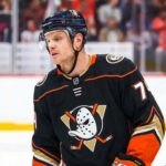 NHL defenseman John Carlson on the ice during a game, subject of Anaheim Ducks contract extension rumors and NHL trade analysis.
