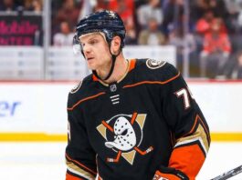 NHL defenseman John Carlson on the ice during a game, subject of Anaheim Ducks contract extension rumors and NHL trade analysis.