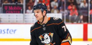 NHL defenseman John Carlson on the ice during a game, subject of Anaheim Ducks contract extension rumors and NHL trade analysis.