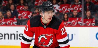 "New Jersey Devils trade target Matthew Knies in a red Devils jersey with number 23 and black helmet, looking focused on the ice.