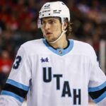 Matthew Knies wearing a conceptual white Utah Mammoth away jersey with a mammoth logo on the chest, illustrating NHL trade rumors involving the Toronto Maple Leafs and the Utah franchise.