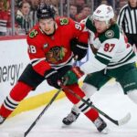 Minnesota Wild star Kirill Kaprizov (#97) and Chicago Blackhawks phenom Connor Bedard (#98) face off, battling fiercely for a loose puck during a recent hockey game.