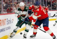 Kirill Kaprizov of the Minnesota Wild battles Matthew Tkachuk of the Florida Panthers for puck possession along the boards during an NHL game, previewing the March 26, 2026 matchup.