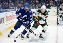 Nikita Kucherov of the Tampa Bay Lightning battles for the puck against Kirill Kaprizov of the Minnesota Wild during their 2025-26 NHL regular season matchup on Tuesday, March 24, 2026.