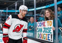 Why the New Jersey Devils Didn’t Trade Dougie Hamilton New Jersey Devils defenseman Dougie Hamilton looks at a hand-painted sign held by a smiling San Jose Sharks fan through the arena glass. The sign reads 'COME TO SAN JOSE DOUGIE!', referencing player movement and trade rumors between the two teams.