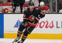 Ottawa Senators #52 MacKenzie Weegar skating with the puck on ice.