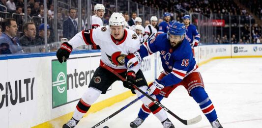 How to Watch Ottawa Senators vs New York Rangers on TV Close-up action photograph capturing Ottawa Senators' captain Brady Tkachuk (#7) and New York Rangers' center Vincent Trocheck (#16) intensely battling for the puck during an NHL game, with a blurred background of spectators and arena boards.
