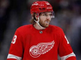 A concept image of St. Louis Blues star center Robert Thomas wearing a red Detroit Red Wings jersey on the ice, highlighting the latest blockbuster NHL trade rumors linking the elite forward to Hockeytown.