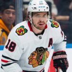 A photo visualization of St. Louis Blues center Robert Thomas in a Chicago Blackhawks white away jersey, linked to offseason trade rumors regarding the NHL trade market.