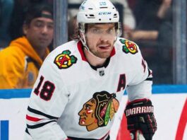 Chicago Blackhawks Trade Rumors: Will They Acquire Robert Thomas? A photo visualization of St. Louis Blues center Robert Thomas in a Chicago Blackhawks white away jersey, linked to offseason trade rumors regarding the NHL trade market.