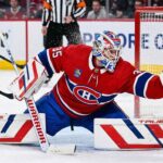 Montreal Canadiens goaltender Samuel Montembeault #35 makes a dramatic diving glove save during an NHL game amidst offseason NHL trade rumors.
