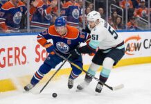 How to Watch Seattle Kraken at Edmonton Oilers on TV (March 31, 2026) Edmonton Oilers captain Connor McDavid (#97) battles for the puck with Seattle Kraken forward Shane Wright (#51).