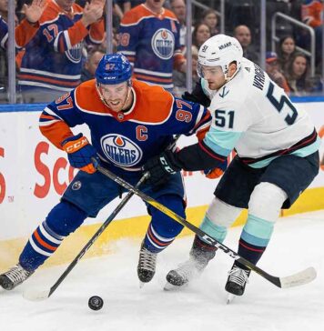 How to Watch Seattle Kraken at Edmonton Oilers on TV (March 31, 2026) Edmonton Oilers captain Connor McDavid (#97) battles for the puck with Seattle Kraken forward Shane Wright (#51).
