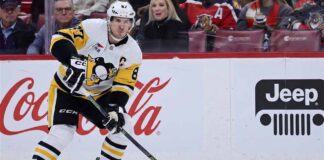Pittsburgh Penguins captain Sidney Crosby skating on the ice wearing number 87 jersey with prominent Coca-Cola and Jeep logos on the boards in the background.