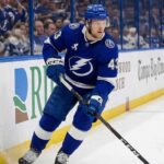 Tampa Bay Lightning hockey player in blue uniform skating with stick during a game, representing breakout defenseman Darren Raddysh.
