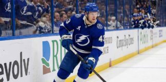 Tampa Bay Lightning hockey player in blue uniform skating with stick during a game, representing breakout defenseman Darren Raddysh.