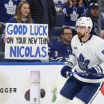 Toronto Maple Leafs center Nicolas Roy skates past a fan holding a "Good Luck On Your New Team" sign, highlighting imminent NHL trade deadline rumors surrounding the forward.