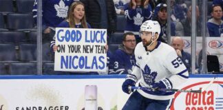 Toronto Maple Leafs center Nicolas Roy skates past a fan holding a "Good Luck On Your New Team" sign, highlighting imminent NHL trade deadline rumors surrounding the forward.