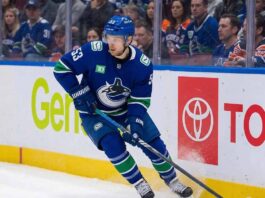 Vancouver Canucks center Teddy Blueger #53 skating on the ice with focused expression during an NHL game, highlighting key team depth.