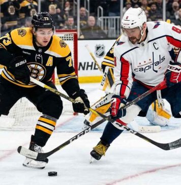 Washington Capitals' Alex Ovechkin battles for the puck with Boston Bruins' Charlie McAvoy during today's NHL game.