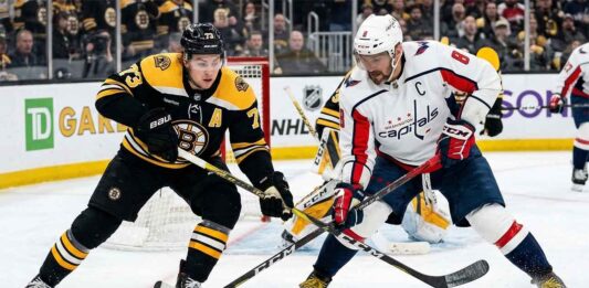 Washington Capitals' Alex Ovechkin battles for the puck with Boston Bruins' Charlie McAvoy during today's NHL game.