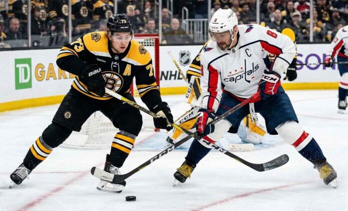 Washington Capitals' Alex Ovechkin battles for the puck with Boston Bruins' Charlie McAvoy during today's NHL game.