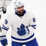 Concept mockup of pending unrestricted free agent Alex Tuch wearing a white Toronto Maple Leafs away jersey and white helmet on the ice.