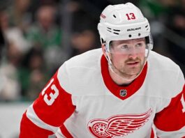 A conceptual photo visualization of current New York Rangers forward Alexis Lafreniere wearing a Detroit Red Wings away jersey, illustrating a potential offseason NHL trade scenario discussed in this post.