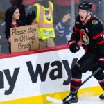 Ottawa Senators captain Brady Tkachuk on the ice wearing the away white jersey amidst NHL trade rumors.