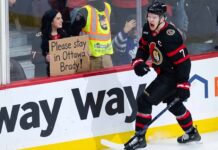 Ottawa Senators captain Brady Tkachuk on the ice wearing the away white jersey amidst NHL trade rumors.