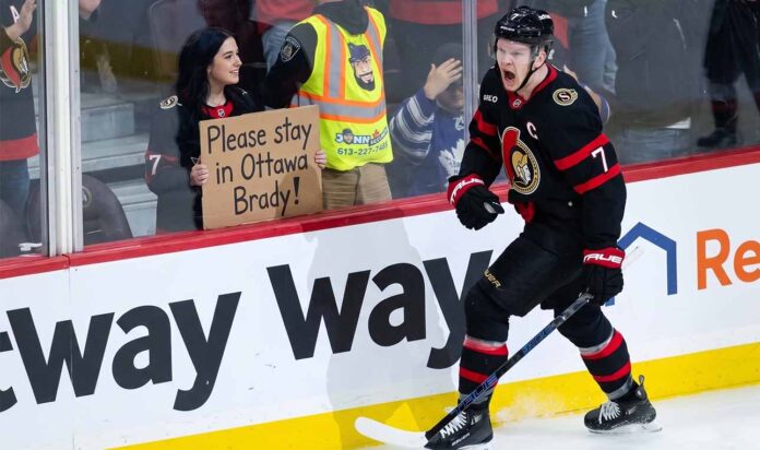 brady-tkachuk-ottawa-senators-trade-rumors Ottawa Senators captain Brady Tkachuk on the ice wearing the away white jersey amidst NHL trade rumors.