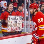 Calgary Flames forward Blake Coleman, wearing jersey number 20, looks at a smiling female fan behind the glass who is holding a hand-made sign that reads "THANKS FOR THE MEMORIES BLAKE!" in an NHL arena.
