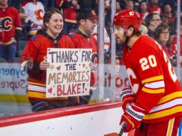 Calgary Flames forward Blake Coleman, wearing jersey number 20, looks at a smiling female fan behind the glass who is holding a hand-made sign that reads "THANKS FOR THE MEMORIES BLAKE!" in an NHL arena.