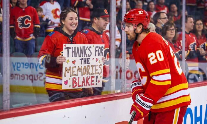 Calgary Flames forward Blake Coleman, wearing jersey number 20, looks at a smiling female fan behind the glass who is holding a hand-made sign that reads "THANKS FOR THE MEMORIES BLAKE!" in an NHL arena.