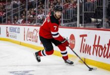 New Jersey Devils defenseman Dougie Hamilton skating with the puck during an NHL game amid offseason trade rumors