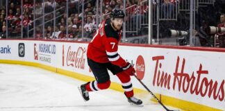 New Jersey Devils defenseman Dougie Hamilton skating with the puck during an NHL game amid offseason trade rumors