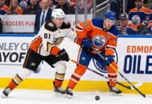 Anaheim Ducks vs Edmonton Oilers playoff action showing Cutter Gauthier battling Connor McDavid for the puck during 2026 Stanley Cup Playoffs Game 5.