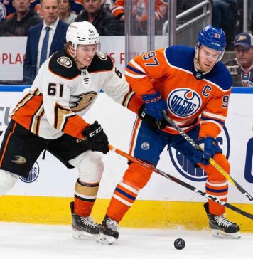 Anaheim Ducks vs Edmonton Oilers playoff action showing Cutter Gauthier battling Connor McDavid for the puck during 2026 Stanley Cup Playoffs Game 5.