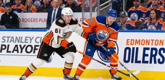 Anaheim Ducks vs Edmonton Oilers playoff action showing Cutter Gauthier battling Connor McDavid for the puck during 2026 Stanley Cup Playoffs Game 5.