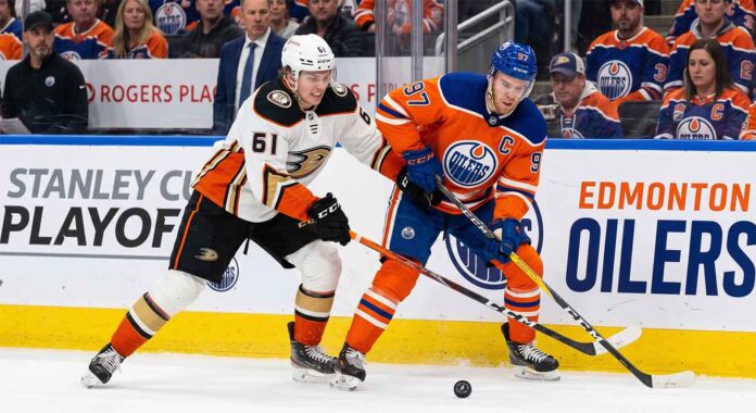 Anaheim Ducks vs Edmonton Oilers playoff action showing Cutter Gauthier battling Connor McDavid for the puck during 2026 Stanley Cup Playoffs Game 5.