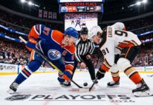 Edmonton Oilers captain Connor McDavid (#97) and Anaheim Ducks center Leo Carlsson (#91) taking a face-off at center ice during NHL Playoffs Game 1 at Rogers Place.