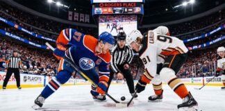 Edmonton Oilers captain Connor McDavid (#97) and Anaheim Ducks center Leo Carlsson (#91) taking a face-off at center ice during NHL Playoffs Game 1 at Rogers Place.