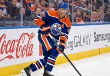 Edmonton Oilers defenseman Darnell Nurse (#25) skating with the puck on the ice during an NHL hockey game.