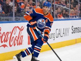 Edmonton Oilers defenseman Darnell Nurse (#25) skating with the puck on the ice during an NHL hockey game.