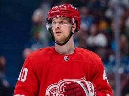 Elias Pettersson Trade Rumors: Will the Detroit Red Wings Acquire the Canucks Star? An NHL action shot featuring superstar center Elias Pettersson wearing a Detroit Red Wings home jersey, with the Red Wings' winged wheel logo.