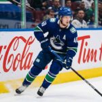 Vancouver Canucks alternate captain Elias Pettersson (number 40) skating on ice during an NHL game, controlling the puck.