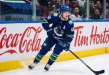 Vancouver Canucks alternate captain Elias Pettersson (number 40) skating on ice during an NHL game, controlling the puck.